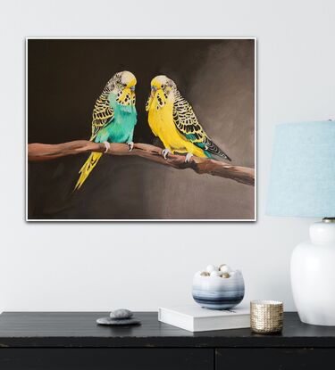 Two budgerigars sitting on a branch.