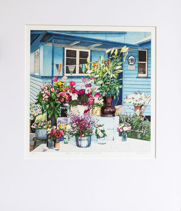 Market Stall in front of the original blue & white painted  Eumundi CWA Hall.  Vases and containers of brightly coloured country style flowers stand on different levels covered in lace tablecloths with a colourful striped bunting hanging above the stall.