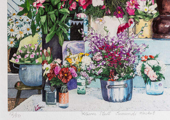 Market Stall in front of the original blue & white painted  Eumundi CWA Hall.  Vases and containers of brightly coloured country style flowers stand on different levels covered in lace tablecloths with a colourful striped bunting hanging above the stall.