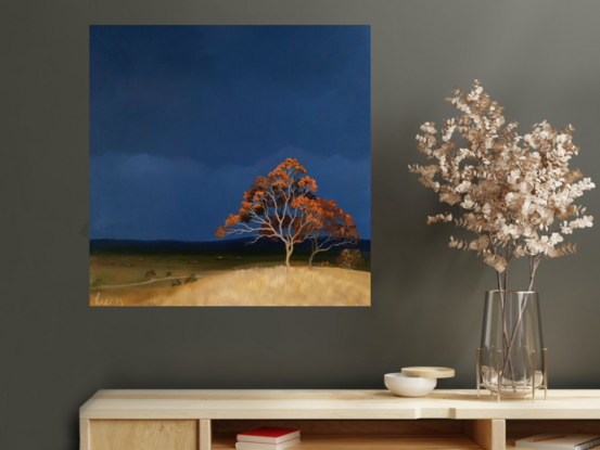 Australian landscape with a deep blue sky and orange trees on the hill in the foreground