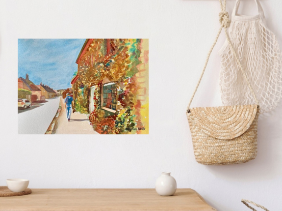 artwork showing a man walking along a street fronted by an ivy covered cottage
