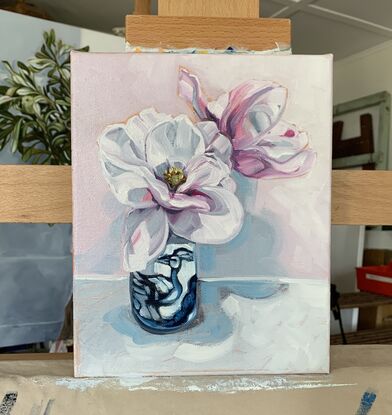 white and pink blush magnolia flowers in a blue and white bird vase