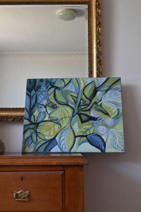 Layers of paint in broad leaf and flower shapes overlap in a colours ranging from silvers, blues, greens, pinks amid highlights of black and white.