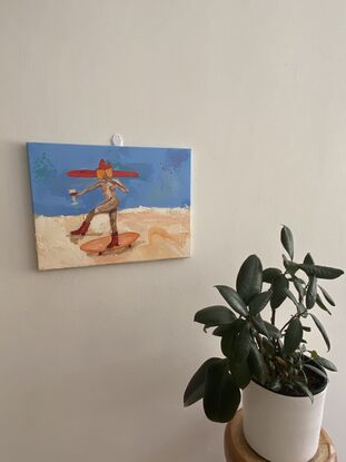 Nude figure  rides skate board, wearing an oversized red cow girl hat, and matching red cowgirl boots, holding an orange book with the title “girls doing things” in one hand and a glass of red wine in the other 