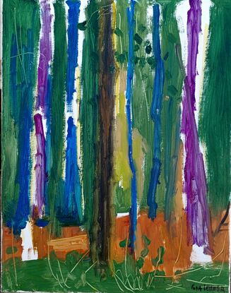 Variously colored tree trunks against the green background of the woods 