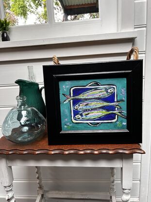 Silver coloured fish on a dish , 3 fish on an enamel dish, blue green sea and fish, pretty coloured fish, blue enamel dish with silver fish, kitchen dish and fish, sardines, whimsical, aqua, dark blue.
