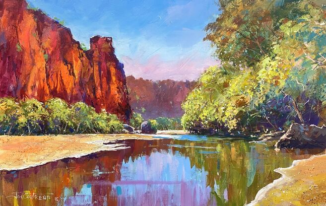 Windjana Gorge with clear water and blue sky. Rocks in vibrant colour. 