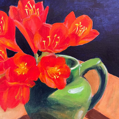 Orange clivia in a mid green Art Deco milk jug on a deep blue background.