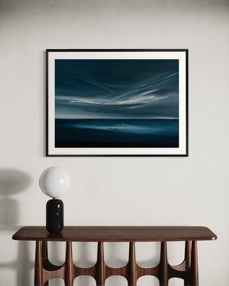 Dark blue ocean and sky with light through clouds and on the horizon. Light reflected on deep blue water. Framed and ready to hang. Modern expressive cloudscape over ocean in deep blue