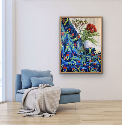 Red gum blossom in a tall glass vase on Lorikeet patterned fabric in bright blues and reds