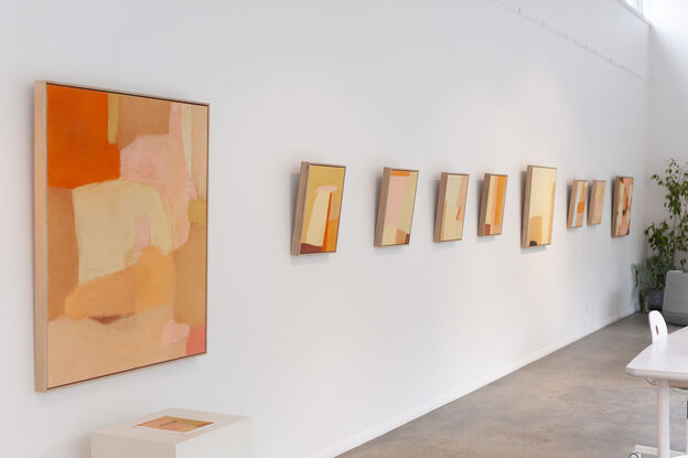 Long abstract shapes run down the canvas in light pink, gold ochre, medium orange and brown ochres, in an abstract composition that lines each colour next to each other.