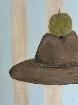 Green apple sitting on top of cowboy hat