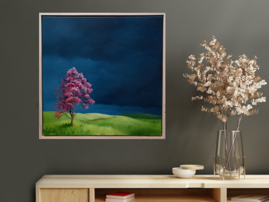 Australian landscape with deep blue skies, vibrant green hills and a red tree in the foreground