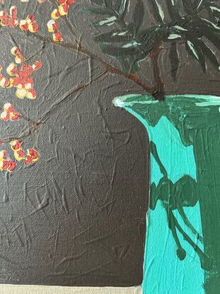 A tall deep aqua coloured vintage jug sits on a sideboard. In it are bare branches with berries light red in colour. They cast a shadow on the jug and the background is a dark grey.