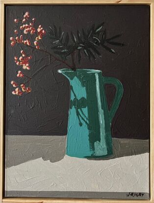 A tall deep aqua coloured vintage jug sits on a sideboard. In it are bare branches with berries light red in colour. They cast a shadow on the jug and the background is a dark grey.