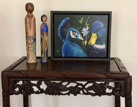 A blue peacock with a blue duck who are best friends