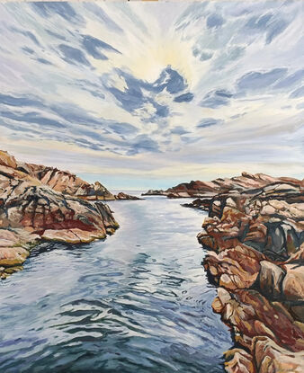 Sun setting on the West coast of Australia, tourist hotspot Canal Rocks. Water reflecting the explosion of clouds in front of the bright sun. Water channel bordered by the warm tones of granite rocks 