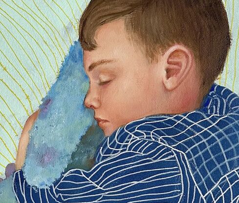 A boy curled up sleeping on his side. He is holding a stuffed toy from Monsters Inc. (Sully).