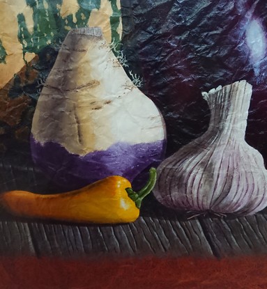 A large striped pumpkin surrounded by a variety of purple vegetables sitting on an old timber bench.