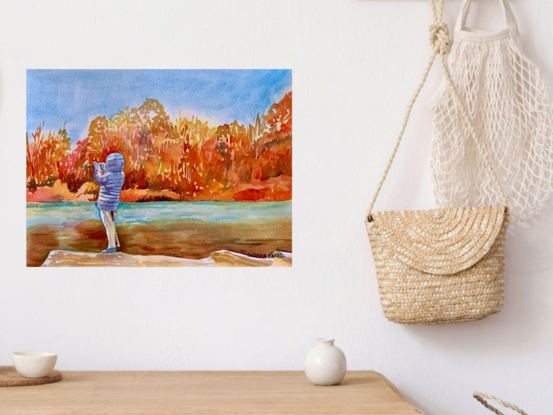 artwork showing a young person taking a photo across a sunlit autumn coloured stretch of water