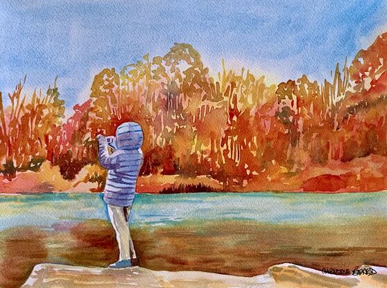 artwork showing a young person taking a photo across a sunlit autumn coloured stretch of water