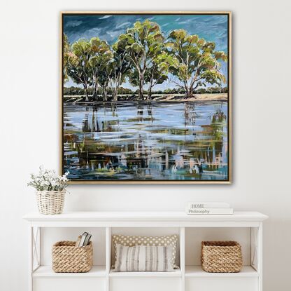 Gum trees line the edge of the Murray river with a beautiful reflection in the water. 