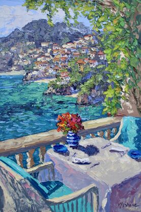 Teal chairs bask in the sun invite the viewer to take in the seaside view from the table on the cliffs above Portofino.  A vase of flowers, plates and napkins are on a white tablecloth.