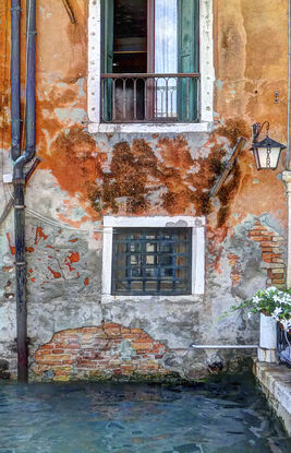 Waterfront wall and windows on canal in Venice, Italy