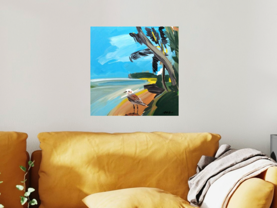 A plover standing in the foreground of a beach scene with water, sand and palm trees.