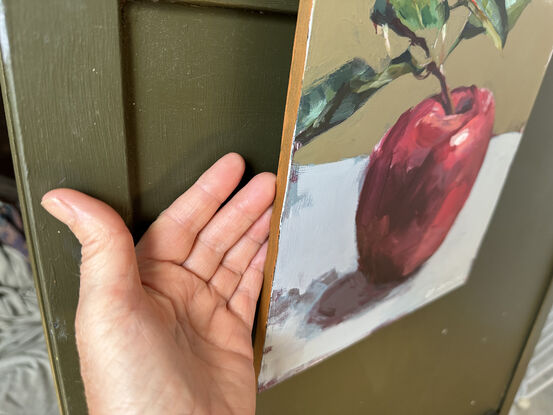 An original, expressive painting of an apple with leaves, painted on board in acrylic paints with visible brush work, ready to hang with chord fastened to the back. 