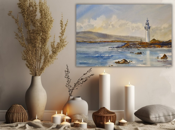 A lighthouse seascape with a backdrop of mountains.