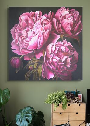 Close up of three deep pink peonies against a dark background