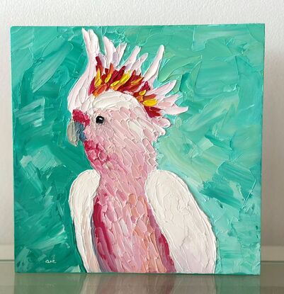 A painting of an Australian Pink Cockatoo on a turquoise background.