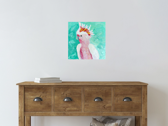 A painting of an Australian Pink Cockatoo on a turquoise background.