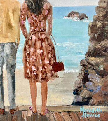 A young couple looking out to sea. He with dark hair, wearing  a white linen shirt. She with blonde hair and a warm brown dress.