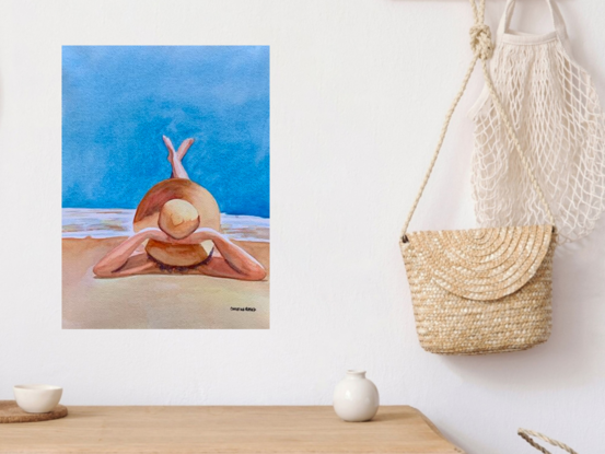 artwork showing a woman with a large sun hat lazing on the beach with her legs stretched out enjoying the sun
