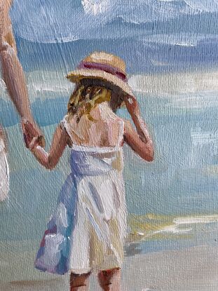 A mother and daughter dressed in white dresses and matching straw hats stroll along the seashore 