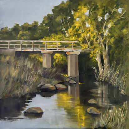 Old stone and timber bridge over a creek with autumn toned trees.