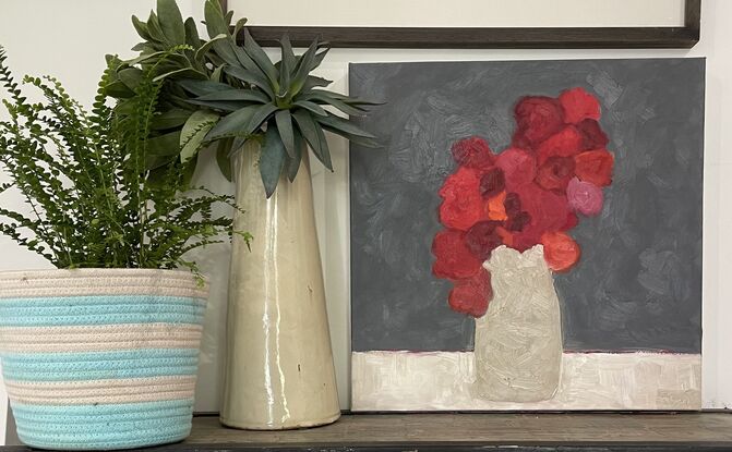 Red flowers in tall neutral vase