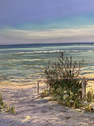 A dynamic day in the beach with waves and a stormy sky with reflections in the sand 