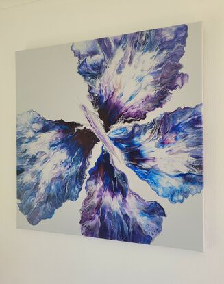 This beautiful vibrant butterfly was created using the acrylic pouring method on a light grey background with various blues purples and silver it truly shines from all angles.
Its four wings spread out as far as they can go over the canvas showing the butterflies true beauty in motion.