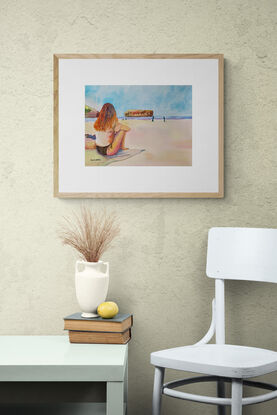 artwork showing a woman in bikini sitting on the beach watching people playing at the edge of the water
