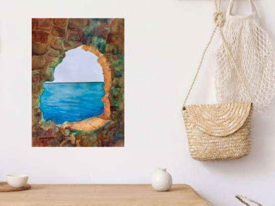 artwork showing an ocean view through the window in a rocky wall 
