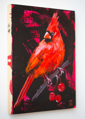 Small painting on wood panel of red cardinal bird perched on a branch with cherry like fruit against a black background