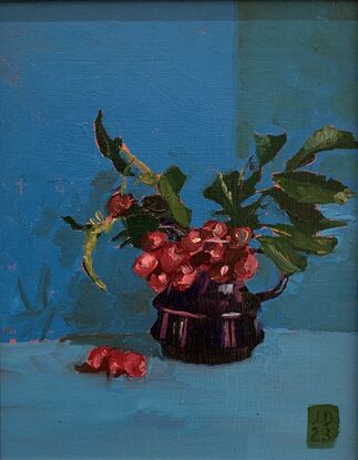 Crimson berries in a navy blue jug.