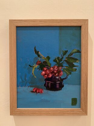 Crimson berries in a navy blue jug.