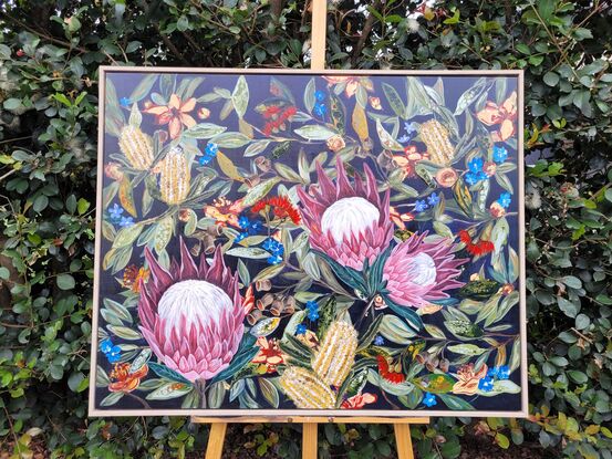 The painting is a vibrant celebration of wild flowers, capturing the essence of the bush with a rich array of colors and textures. At the center of the canvas, 3 magnificent protea commands attention with its bold, intricate petals in shades of pink, purple, red, and white, radiating outwards like a fiery sunburst.
Interwoven with the protea are clusters of banksia flowers, their spikes contrasting beautifully against the protea's rounded forms. Eucalyptus branches gracefully scattered across the canvas, the array of different hues of green leaves shimmering in the dappled light, providing a cool and warm contrast.
Small wildflowers peek out from amongst the larger blooms, adding a pop of blue, gum nuts in flower scatter around the canvas .
this mesmerising artwork is a beautiful combination of wild flowers