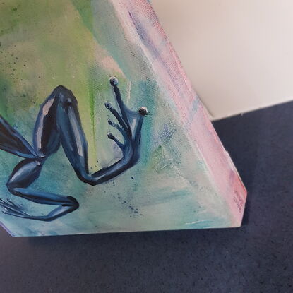 Pale blue and green background with a blue frog with long legs bent at an angle.