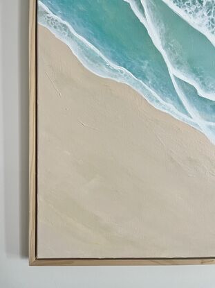 Aerial beach scape with rolling waves and an empty beach with beautiful tan and blush sand 