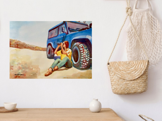 artwork image of a woman sitting on the ground leaning against a Landrover jeep looking at the view through binoculars 
